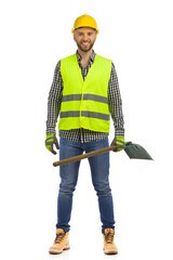 Relaxed happy construction worker is standing with shovel. Front view. Studio shot isolated.