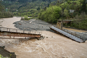 A bridge over a mountain river destroyed by water