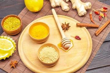 Dry ginger and turmeric powder in bowls, stick with honey.
