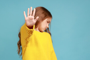 Portrait of serious little girl showing stop gesture, warning to go, looking angry dissatisfied,...