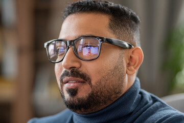 Head of mature man in eyeglasses sitting in front of laptop and looking at student on screen during...