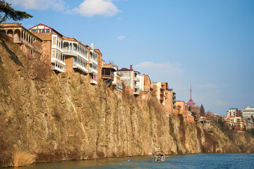 Old architecture of Tbilisi. Dense development of a residential building on a cliff by the river