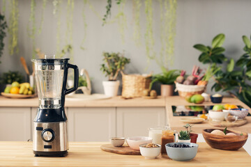 Electric blender and group of bowls with ingredients for smoothie standing on wooden table in kitchen environment