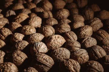 Walnuts background. Tasty nut is diet snack. Close-up. Copy space. Healthy food. Drying harvest. Useful brain nutrients. Brown color. Wallpaper. Banner. Beautiful still life on dark backdrop. Texture