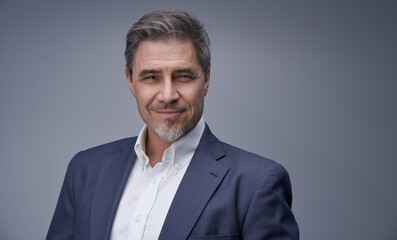 Business portrait - businessman smiling, jacket and open collar white shirt. Mature age, middle age, mid adult man in 50s with gray hair and happy confident smile. Copy space.
