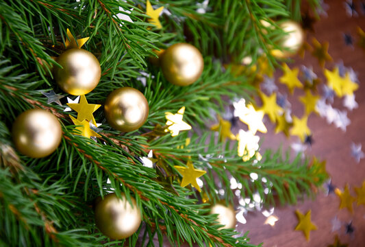 Beautiful Christmas still life with golden balls on a spruce branch stock images. Christmas spruce twigs with gold stars shape decorations on a wooden background stock photo