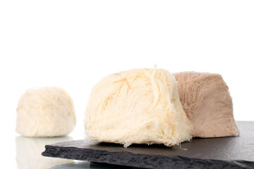 Several sweet cotton candy on a slate stone, close-up, isolated on white.