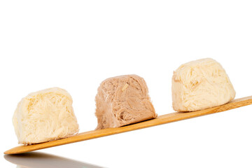 Three sweet cotton candy on a spatula made of wood, close-up, isolated on white.
