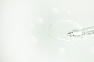 Drops from a pipette. Liquid gel or serum on a microscope screen on a white background