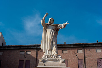 statue of savonarola with the background of the Este castle