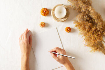Autumn and winter checklist goals and woman hands, candle and dry pampas grass