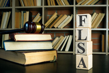 Books, gavel and cubes with FLSA or Fair Labor Standards Act.