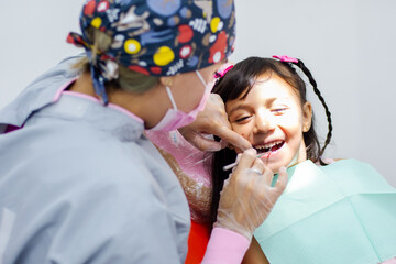 Female doctor inspecting a girl's teeth at the dentist's office