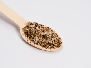 salt with algae on a wooden spoon spice used in the kitchen, macro photo lots of details, white background, eco concept