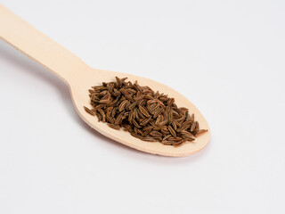 cumin on a teaspoon spice used in the kitchen, macro photo many details, white background, reflection in the base