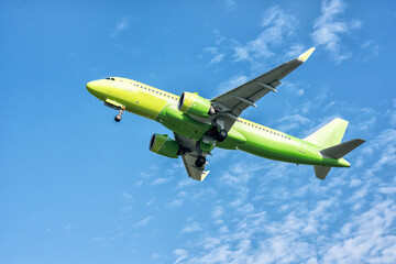 A big yellow jet flying on background of blue sky.