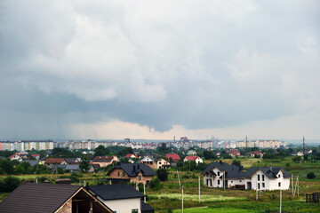 Obraz premium Landscape of dark clouds forming on stormy sky during thunderstorm over city rural area.