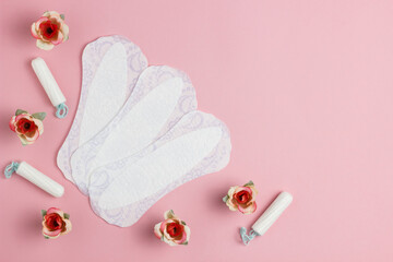 Feminine hygiene panty liner for menstruation. Menstrual cycle, pad. pink background. Tampons, rose inflorescences