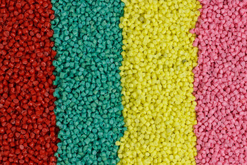 Lots of green, blue, red, yellow, pink granules of polypropylene, polyamide. Chemical products. Plastic, polymers and microplastics.