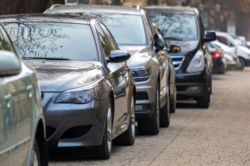 Cars parked in a row on a city street side.