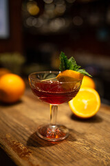 cocktail in the dark with oranges on the bar