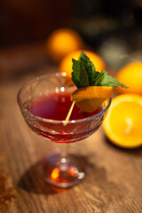 cocktail in the dark with oranges on the bar