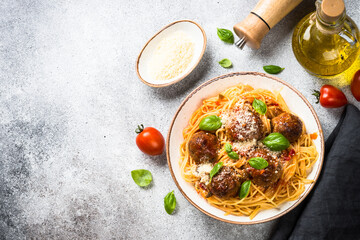 Pasta with Meatballs in tomato sauce, basil and parmesan on stone table. Top view with copy space.