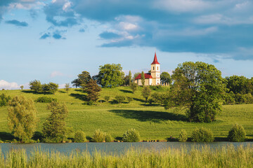 Church on the hill with lake in foreground. Bysicka church near SPA town Lazne Belohrad, Czech Republic.