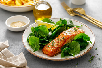 Grillet salmon and fresh spinach salad dressed with lemon