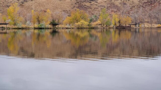 fishing lake with picnic shelters at foothills of Colorado Rocky Mountains, calm fall evening scenery at Watson Lake State Wilderness Area