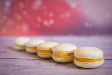 white macaroons cakea with yellow cream on the pink background and stars on the wall