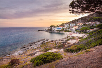 View at sunset over sandy beach of little village Seccheto at end of season at Island of Elba,...
