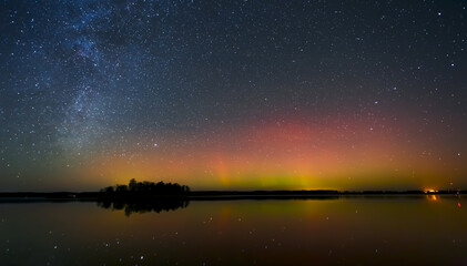 Fototapeta na wymiar Milky way and Northern lights - Aurora borealis over the lake in Lithuania