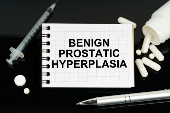 On the black surface are pills, a syringe and a notebook with the inscription - Benign Prostatic Hyperplasia