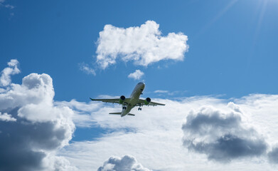 View of the plane before landing in the cloudy sunny sky.