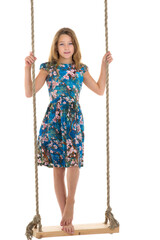 Girl standing on rope swing.Portrait of happy preteen child