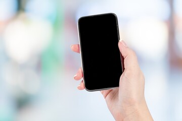 A hand holding a smartphone with a blank screen