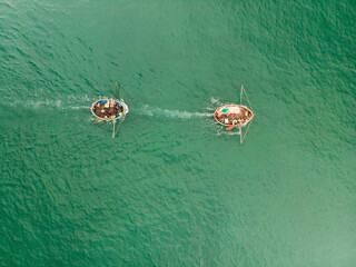 Aerial view of traditional vietnamese fishing boats sailing on emerald South China Sea, Vietnam