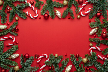 Red Christmas background with decorative frame of fir branches and decorations