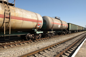 Freight cars and tanks with liquid on the railway on the background of the railway at the station