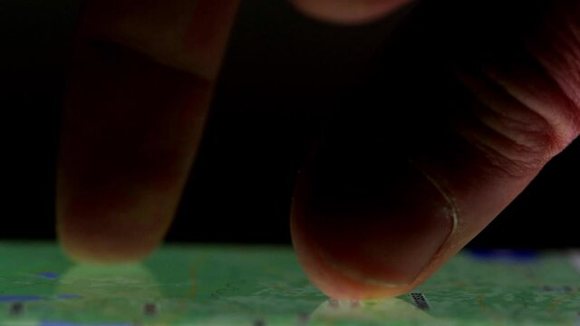User's finger point and zoom and search on interactive maps on smartphone screen. Pinch to zoom on online map