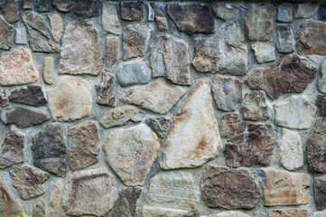 Background well-hewn stones different sizes, smooth surface old wall, close-up vintage texture background, grungy building facade.