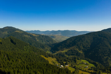 Fototapeta na wymiar Beautiful landscape with forest and village in mountains. Drone photography