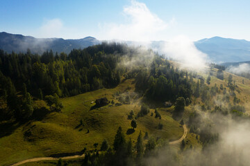 Beautiful landscape with village and forest in misty mountains. Drone photography