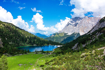Naklejka na ściany i meble The Seebensee in Austria in Tyrol in the valley between two rock faces with a view of the Zugspitze.