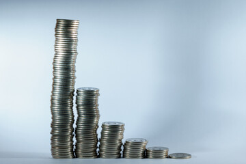 Stacks of coins in a descending progression. Business economic crisis and bankruptcy concept