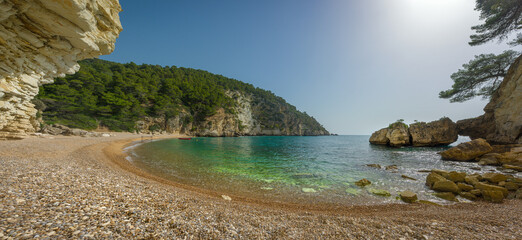 Secluded coastal beach of Portogreco in Gargano National Park, Puglia, Italy, with eroded limestone...