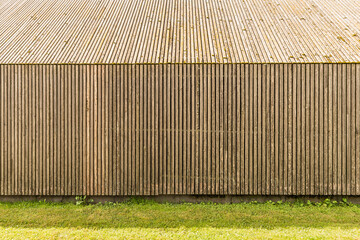 Closeup view of wooden slat wall and pitched roof of building