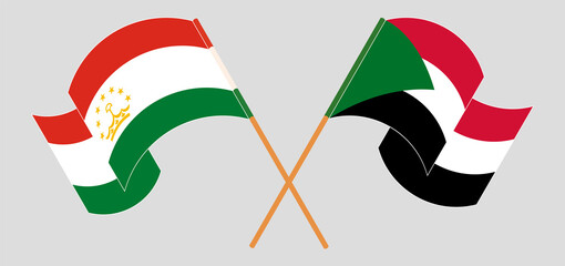 Crossed and waving flags of Tajikistan and the Sudan