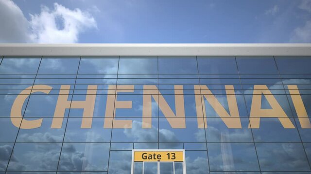 Commercial airplane reflecting in airport terminal with CHENNAI text